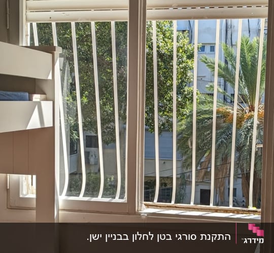 סורגים ממתכת עם בטן בצבע לבן בחלון חדר